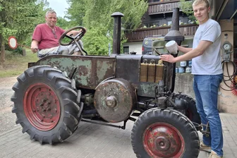 Mit Dreschflegel und Vorheizlampe: Sommerfest der Feuerwehr Niederwiesa mit historischer Technik - Jan Schild (l.) hat den Lanz Bulldog wieder fit gemacht. Der Niederwiesaer ist wie sein Sohn Lorenz (r.) aktives Feuerwehrmitglied. Foto: Knut Berger