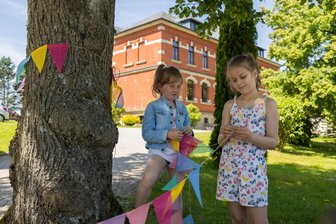 Mit eigenem Song: Wie eine Grundschule im Vogtland Jubiläum feiert – „Das ist einmalig“ - Die achtjährige Leonie (links) sowie die siebenjährige Malou machen das Außengelände ihrer Schule schön.