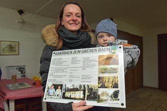 Mit einer besonderen Aktions ins Jubiläumsjahr: In Dorfchemnitz klebt das Geschichtsbuch jetzt an der Hauswand - In Dorfchemnitz wird ein besonderes Ortsbild-Vorhaben realisiert: Zunächst erhalten 30 Objekte des Dorfes Informationstafeln zum Werdegang des Hauses und seiner Besitzer berichten. Cindy Buschmann freut sich mit Sohn Alexander über die Tafel fürs traditionsreiche Familien-Objekt.