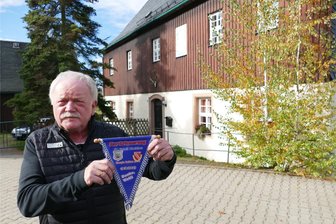 Mit erzgebirgischer Leidenschaft und Cottbusser Energie: Wie ein Lehrer aus Börnichen dem DFB wichtige Tipps gab - Vor dem Börnichener Forsthaus, in dem er aufwuchs und heute noch wohnt, präsentiert Wolfgang Neubert einen Wimpel von 2013. Da wurde der sanierte Börnichener Fußballplatz mit einem Spiel gegen die Cottbusser A-Junioren eingeweiht.