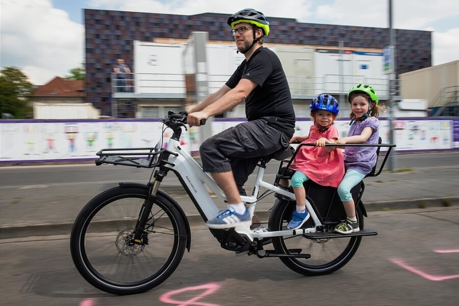 Mit Fördergeld zum Lastenrad - Papa hat das coolste Fahrrad: Auf dem Heckträger dieses E-Cargobikes fahren zwei Kinder mit.