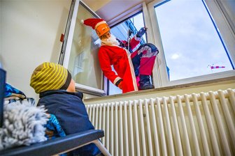 Mit fünf Tagen Verspätung: Nikolaus seilt sich im Erzgebirge vom Klinikum ab und bringt Geschenke - Überraschung durchs Fenster: Ein Nikolaus – hier im Bild Robin Fleck von der Höhenrettungsgruppe Aue-Schwarzenberg – hat am Montag den Kindern im Auer Klinikum Geschenke gebracht.