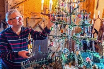 Mit Gänsefedern: Schönheider Museum zeigt ganz besonderen Weihnachtsbaum - Museumsleiter Andreas Schubert an dem Weihnachtsbaum, bei dem die Äste aus Gänsefedern sind. Der stammt aus dem Jahr 1925.