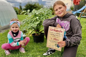 Mit Hasenmist zum Sieg: Zwei Schwestern gewinnen Garten-Wettbewerb im Erzgebirge - Elisa (l.) und Helena Paatsch sind stolz auf den Siegerpokal und die Urkunde.