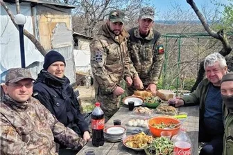 Mit Hilfsgütern in die Ukraine, mit Kriegseindrücken zurück: Ein Erzgebirger auf Frontbesuch - Nicht immer geht es so friedlich zu: Der Ukrainehelfer Silvio Uhlig (zweiter von links) beim Essen mit ukrainischen Kämpfern. Der Erzgebirger trägt bei seinem Besuch im Kriegsgebiet auch eine Kalaschnikow zur Selbstverteidigung und eine schusssichere Weste.