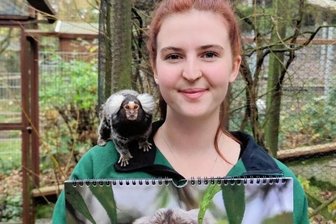 Mit Minis durch das Jahr 2023 - Josie Nöbel mit einem Weißbüscheläffchen - auf ihrer Schulter und im Kalender. 