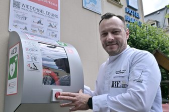 „Mit nichts zu entschuldigen“: Stadt im Erzgebirge will Defibrillatoren jetzt besser vor Vandalen schützen - Am Hotel „Blauer Engel“ in Aue ist ein mobiler Defibrillator angebracht; im Bild: Geschäftsführer Benjamin Unger.