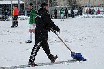 Mit oder ohne Schnee: RFC will spielen - Auf verschneitem Kunstrasen: RFC-Torwarttrainer Lutz Rodewald macht die Strafraumlinie frei.