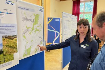 Mit Security: Windanlagen-Entwickler kommt in Dittmannsdorf mit Bürgern ins Gespräch - Juwi-Projektleiterin Janine Göhring spricht mit einem Besucher über die zu erwartenden Immissionen der Windenergieanlagen.