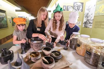Mit Zaubersalz und Entdeckerblatt: Ferienkinder rätseln auf Schloss Augustusburg - Julie Lena Franke vom Gästeservice (2.v.l.) mischt mit Besuchern des Ferienaktionstages auf der Augustusburg (v.l.: Johanna/8, Liliana/12 und Elias/10) Kräutersalz. Die Zutaten sind Salz, Pfeffer, Nelke, Salbei und Zimt.