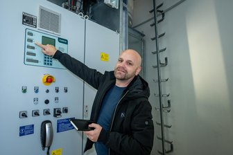 Mittelsachsen will bei Windkraft-Ausbau bremsen: Was das für Investoren bedeutet - Geschäftsführer Eric Müller weist in einem Windrad im Windpark Erlau auf die angezeigten Daten zur Stromerzeugung hin.