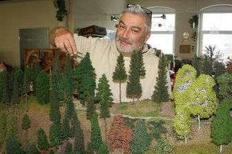 Modellbahner in Neukirchen: Wo vor der Saison noch die Baumpflege ansteht - Till Weigel fixiert auf der neuen Anlage Bäume.