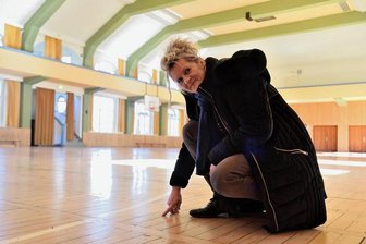 Modernisierung der Oelsnitzer Vogtlandsporthalle: Was geht und was nicht - Stadtbaumeisterin Kerstin Zollfrank zeigt auf das über 100 Jahre alte Parkett in der Vogtlandsporthalle in Oelsnitz. Im Zuge der Teilsanierung wird ein Allzweckfußboden mit einer Fußbodenheizung eingebaut. 