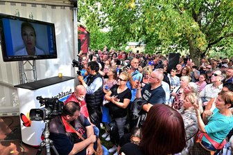 Mödlareuth am Tag der Deutschen Einheit zwischen AfD und CSU: Wo ist Alice Weidel? - Alice Weidel spricht drei Minuten vom Bildschirm. Sie könne nicht anreisen, weil ihre Familie bedroht worden sei.