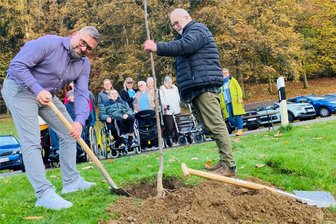 Montanregion Erzgebirge kürt den Obstbaum des Jahres: Was der Safranapfel verspricht - Unter den neugierigen Blicken einiger Bewohner von „Gut Gleesberg“ in Neustädtel haben Hausleiter Jens Bretschneider (l.) und Matthias Scheffler vom Landschaftspflegeverband dieser Tage einen Safranapfel gepflanzt.