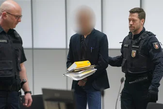 Der Angeklagte (M) wird zu Beginn des Prozesses wegen Vergewaltigung und Mord von Justizbeamten in den Gerichtssaal des Landgerichts Itzehoe im China Logistic Center gebracht.