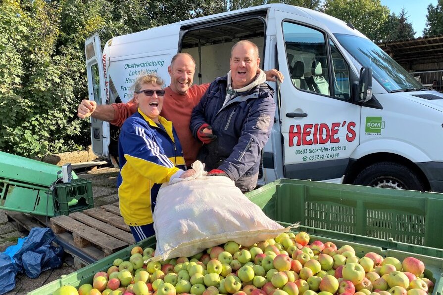 Gute Laune bei der Obstabgabe: Martina Funke aus Frankenberg hat im Garten einer Bekannten Äpfel aufgelesen. Ein Heide-Mitarbeiter (rechts) überprüft, dass beim Wiegen alles stimmt.