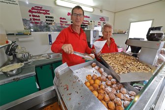 Moto-GP auf dem Sachsenring: Was kosten Bratwurst, Krapfen und Bier? - Heimische Spezialitäten können beim Moto-GP ebenso geschlemmt werden wie internationale Küche. Der Annaberger Krapfenbäcker Ronny Tautenhahn ist das 20. Jahr beim Moto-GP dabei. Gemeinsam mit Verkäuferin Monika Göbel steht er hinter der Honda Tribüne. Drei Krapfen bekommt man hier für 2,50 Euro.