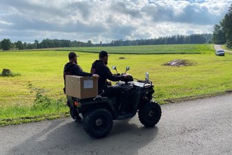 Mühlteich-Wiese in Hauptmannsgrün teilweise gesperrt: Wird das Metal-Spektakel im Vogtland ein Klein-Wacken? - Pendelverkehr zwischen den Parkplätzen und dem Festivalgelände am Hauptmannsgrüner Mühlteich - Andreas Schiller (vorn) und Alex Bierlmaier von der Parkplatz-Crew mussten den im Bild hinten erkennbaren Bereich der Parkplätze sperren. Die Wiese dort ist so rutschig, dass vor allem größere Fahrzeuge Probleme bekommen würden.