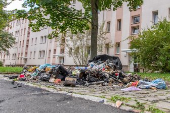 Mülltonnen in Zwickau-Marienthal abgebrannt: Polizei ermittelt - Der verkohlte Abfall liegt überall auf dem Gehweg herum.