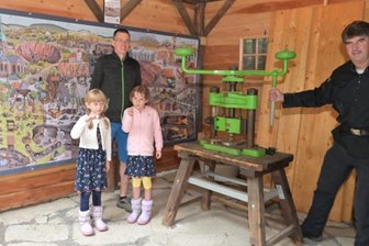 Münze erinnert an Besuch zum Hüttentag - Lars Münzner (links) aus Grünhain mit seinen Töchtern Rania (links) und Felipa an der Münzpräge am Schaubergwerk "Herkules-Frisch-Glück" mit Bergführer Ulrich Lang.