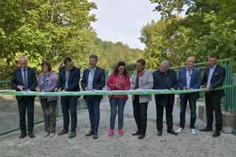 Mulderadweg bei Aue-Bad Schlema führt jetzt über historische Steinbrücke - Neun Frauen und Männer haben das Band durchgeschnitten, das extra für die Freigabe der historischen Steinbrücke in Bad Schlema angefertigt wurde.