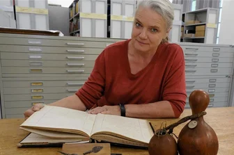 Museum Burg Mylau: Herkunft von 80 Afrika-Objekten zu klären - Museumsleiterin Sina Lorbeer-Klausnitz mit einem Inventarbuch des Naturkundevereins Mylau, Messerklinge und Pfeilspitze der Herero aus dem heutigen Namibia sowie Flaschenkürbis-Gefäßen aus Westafrika. 