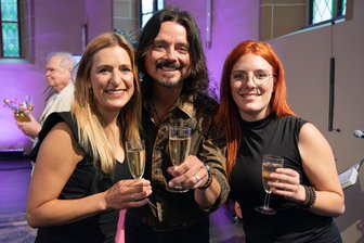 Musikalisch und voller Heimatgefühle: So emotional war das Wiedersehen mit Stefanie Hertel in Oelsnitz - Stefanie Hertel (links), Ehemann Lanny Lanner und Johanna Mross erhoben das Glas auf die Ausstellung über Stefanies Karriere.