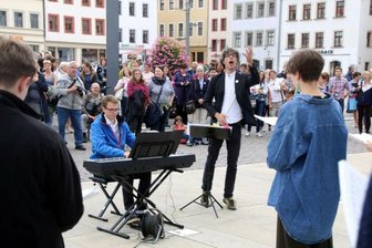 Musikalisches Erlebnisshopping in Freibergs Altstadt - Domkantor Albrecht Koch (M.) dirigiert die Jugendkantorei des Freiberger Domes auf dem Obermarkt. 