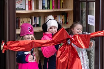 Musikarchiv Erzgebirge: Wo mehr als nur Anton Günther drin steckt - Lizzy, Annika und Saphira (von links) aus dem Hort der Kindertagesstätte „Sonnenhügel“ waren ganz stolz, dass sie zur Eröffnung des öffentlichen Bücherschrankes die große rote Schleife durchschneiden durften.