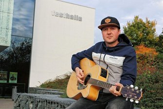 Musiker Christian Wenzel feiert in Plauen Bühnenjubiläum: Warum Tränen in den Augen für ihn das schönste Kompliment sind - Christian Wenzel mit seiner Gitarre vor der Plauener Festhalle. Dort steigt am morgigen Samstag eine große Party zu seinem 20-jährigen Bühnenjubiläum. Eintrittskarten gibt es noch an der Abendkasse. 