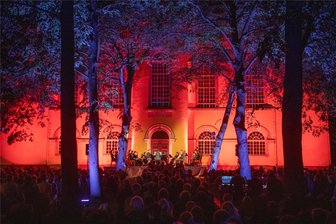 Musiksommer Augustusburg zieht in den Kirchpark: Besucher erleben eine tropische Nacht - Die Open-Air-Veranstaltung im Kirchpark ist ein Musiksommer-Highlight, wie hier 2023 mit Pascal Kaufmann und einem Streichensemble. Die Beleuchtung gibt dem Nachtkonzert eine besonders stimmungsvolle Atmosphäre.