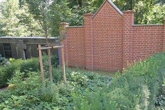 Mut zur Veränderung - ein Ort der Trauer wandelt sich - Nur wenige Meter unterhalb wurde ein Mauerstück komplett neu aufgebaut. Auch davor beschreitet man neue Wege: Hier befindet sich ein Baumgrab.