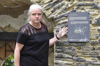 Mylau: Neue Infotafel im Burggarten zerkratzt - Museumsleiterin Sina Lorbeer-Klausnitz an der beschädigten Informationstafel am südlichen Fluchttor im Mylauer Burggarten.