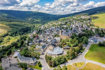 Mysteriöses Donnern am Fichtelberg gibt Rätsel auf - jetzt melden sich die Erzgebirger - Diese Drohnenaufnahme zeigt die Stadt am Fichtelberg. Selbst die Bewohner mitten in Oberwiesenthal hören das dumpfe Grollen und fragen sich, wo es herkommt. 