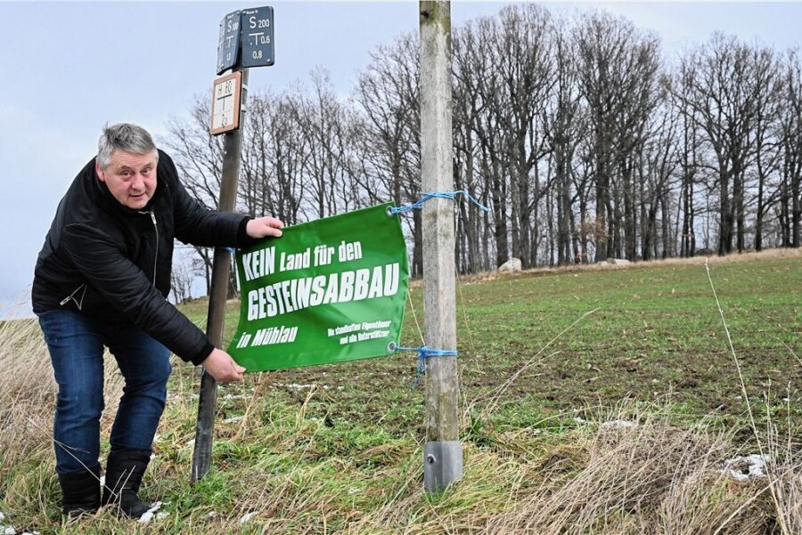 Nach 30 Jahren: Aus für den Steinbruch in Mühlau? - Bürgermeister Frank Rüger zeigt das Plakat "Kein Land für den Gesteinsabbau in Mühlau" nahe des Windbergs in Mühlau. 