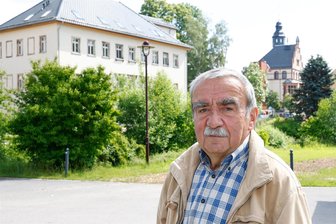 Nach 35 Jahren tritt ein Oberlungwitzer Stadtrat nicht mehr an - Ulrich Hoppe am Oberlungwitzer Meisterhaus, über das viele Jahre diskutiert wurde. Im Hintergrund ist das Rathaus zu sehen.
