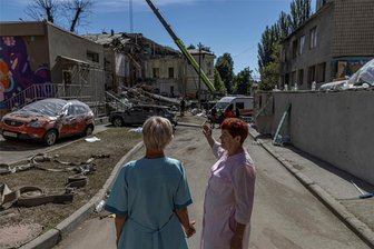 Nach Angriff auf Kiewer Kinderklinik: Können Krankenhäuser im Vogtland helfen? - Mitarbeiterinnen beobachten, wie Rettungskräfte die Trümmer des Kinderkrankenhauses Okhmatdyt in Kiew beseitigen, das am 8. Juli von russischen Raketen getroffen wurde.