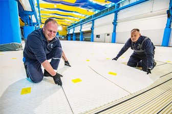 Nach Ansturm im Vorjahr: Icehouse in Aue startet mit Eislaufsaison einen Monat früher - Hausmeister Oliver Reschke (links) und Eismeister Thomas Heinke verlegen im Icehouse in Aue die Platten, auf denen später das Eis aufgespritzt wird.