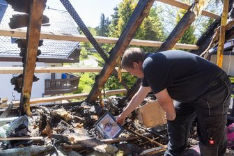 Nach Brand im Erzgebirge: Wie eine Familie versucht, wieder in den Alltag zu finden - Emotionaler Moment: Michael Hilbrich entdeckt im Brandschutt des zerstörten Dachbodens ein Foto, das die Flammen nicht vernichtet haben.