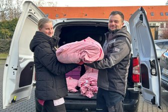 Nach Brand in der Wäscherei der Lebenshilfe in Oederan: Regenbogenhaus Freiberg wäscht jetzt für drei Awo-Kitas - Einmal in der Woche tauscht Rico Malek, Hausmeister in den Awo-Kitas, die Wäsche im Regenbogenhaus. Maja Liebeck, die im Regenbogenhaus zur Helferin im Gastgewerbe ausgebildet wird, hilft beim Einladen.