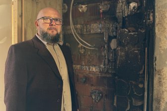 Nach Brandstiftung in Frankenberg: Schulleiter fassungslos über „sinnlose Zerstörung“ - Schulleiter Dirk Rauthe vor einem Stück verkohlter Fassade in der Erich-Viehweg-Schule.