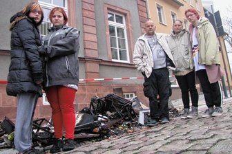 Nach dem Wohnungsbrand in Geringswalde: Der schwere Weg einer Familie zurück ins Leben - Mia, Syndia, die Eltern Jens und Melanie Hammer sowie Saskia (v. l.) stehen vor einem Teil der völlig verkohlten Einrichtung ihrer Wohnung. 