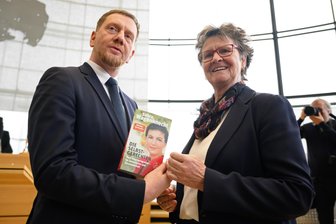 Nach der Bundestagswahl: Welchen Einfluss hat das knappe BSW-Scheitern auf die Mehrheitsverhältnisse im Landtag? - Ob er es schon gelesen hat oder nach der Bundestagswahl darauf verzichtet? Ministerpräsident Michael Kretschmer (CDU) mit dem von Sachsens BSW-Chefin Sabine Zimmermann überreichten Buch von Parteigründerin Sahra Wagenknecht.