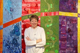 Nach der Rundreise durch halb Deutschland: Artquilts im Textil- und Rennsportmuseum Hohenstein-Ernstthal - Evi Mühlstedt vor dem Werk „Oberflächengestaltung“ der Künstlergruppe „TexARTists“.