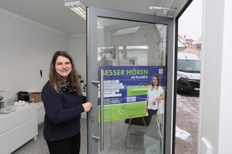 Nach der Sprengung des Geldautomaten in Zwickau-Planitz: Am einst einsturzgefährdeten Gebäude kehrt wieder Normalität ein - Nadine Schneider öffnet die Tür zum Hörgeräteservice. Das Gebäude wurde saniert.