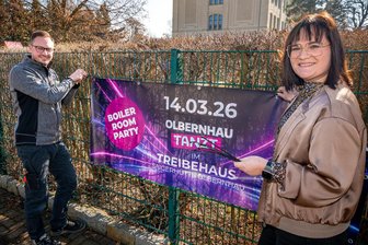 Nach Disco-Aus im Erzgebirge: Olbernhau startet neues Tanzformat - Max Steudel und Cheyenne Worotnik hängen einen Werbebanner für „Olbernhau tanzt“ auf.