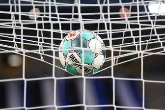 Ein Fußball liegt vor der Partie im Netz.