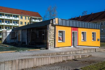 Nach Explosion in Bankfiliale in Schneeberg: Wie es jetzt für Polizei, Sparkasse und Friseursalon weitergeht - Der Salon der Genossenschaft „Ihr Friseur“ in Schneeberg steht noch. Der Servicepunkt der Sparkassen(links) wurde nach der Explosion abgerissen.