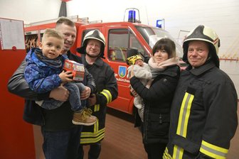 Nach Geburt im Neukirchner Gerätehaus: Kameraden der Feuerwehr werden Paten von Thill - Als Thill zwei Wochen alt war, besuchte er auf dem Arm von Mama Mandy, mit Papa Andreas und Bruder Tim seine "Geburtshelfer" von der Feuerwehr, hier Volker Ludewig (h. l.) und Falk Lucius (r.). 